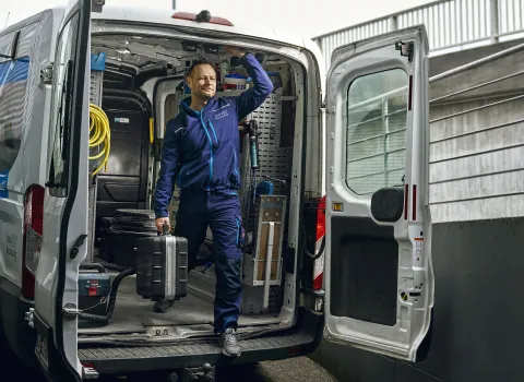 Kundendienst-Monteur SHK steht startbereit im Firmenwagen