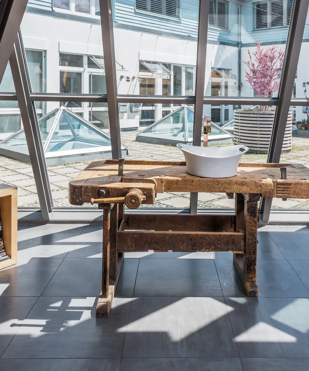 Showroom mit einer Armatur und Waschbecken auf einem Holzwaschtisch.